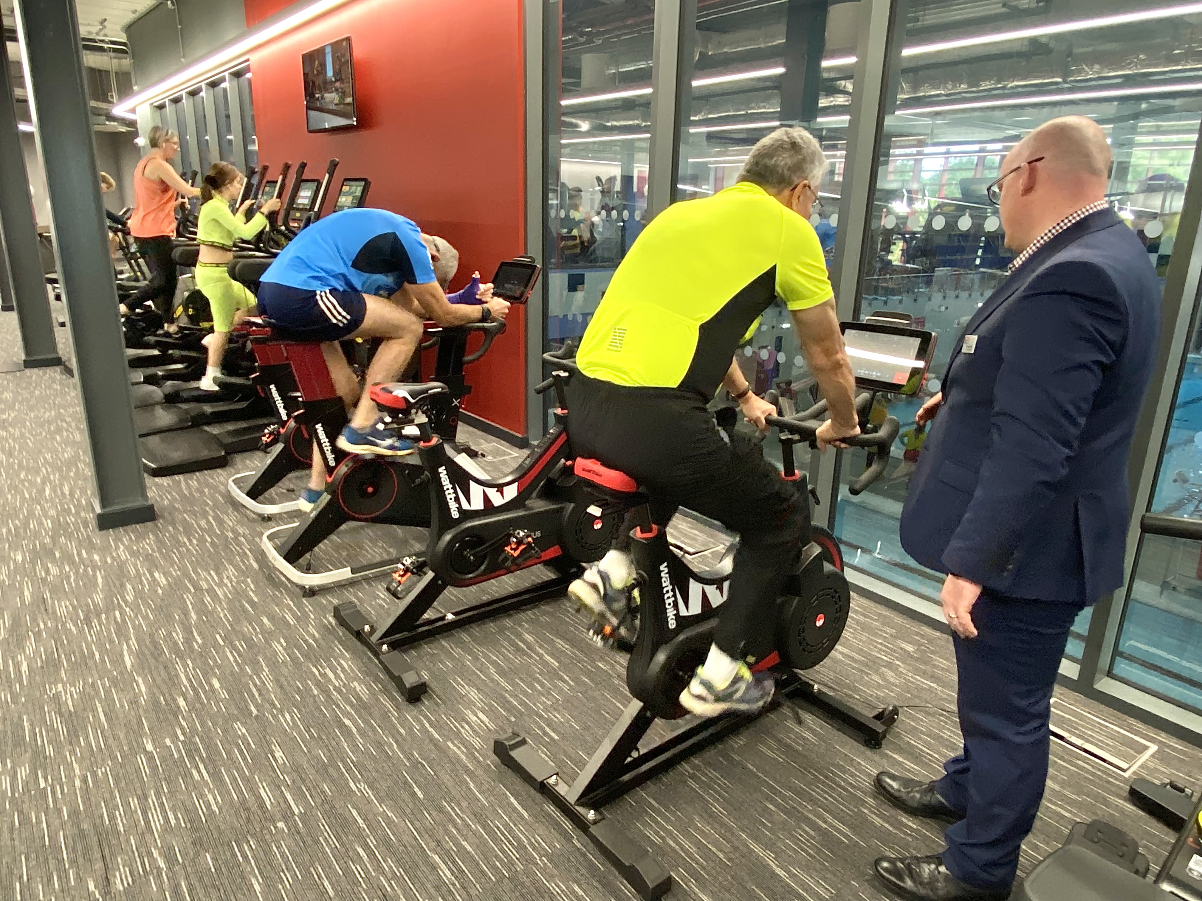Councillor Eric Buckmaster and other members of public on gym bicycles