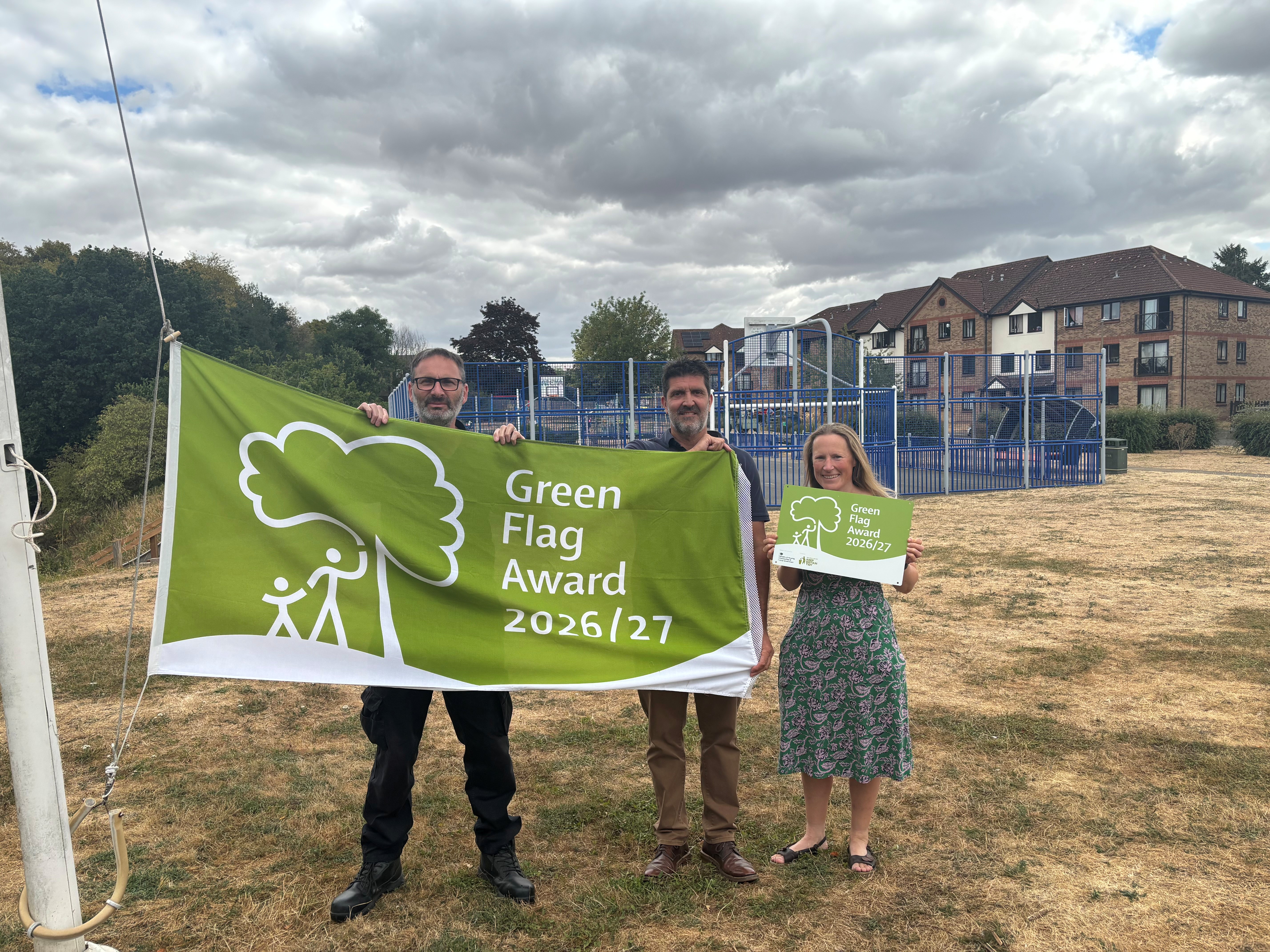Officers and Executive Member for Wellbeing holding the Green Flag at one of the parks