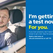 Man in a car with "I'm getting a test now" writing in white