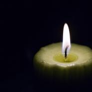 A single lit candle on a black background