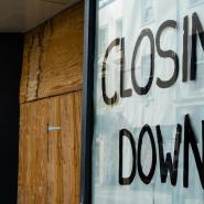Shop front with closed down sign and door boarded up
