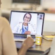 Doctor on laptop screen doing online consultation