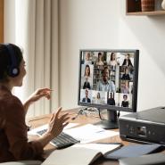 Woman in front of computer listening to webinar