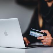 Person using a laptop looking at a credit card