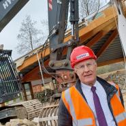 Pictured: Eric Buckmaster at the construction site with JCB behind him during the demolition