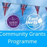 landscape image - top half is blue sky with some clouds and union jack bunting going across with the logos for East Herts Council and official logo of the Queen's Platinum Jubilee. The bottom half is a pale blue background with text that reads "Community Grants Programme"