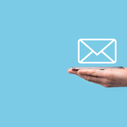 on a blue background, a hand holds a phone in it's palm with the outline of a letter hovering above it.