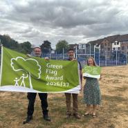 Officers and Executive Member for Wellbeing holding the Green Flag at one of the parks
