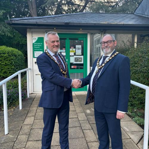 Councillor John Dunlop shaking hands with Councillor Martin Adams