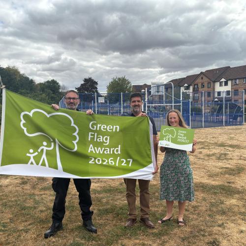 Officers and Executive Member for Wellbeing holding the Green Flag at one of the parks