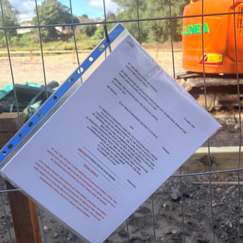 Paper order placed on fence of site of works